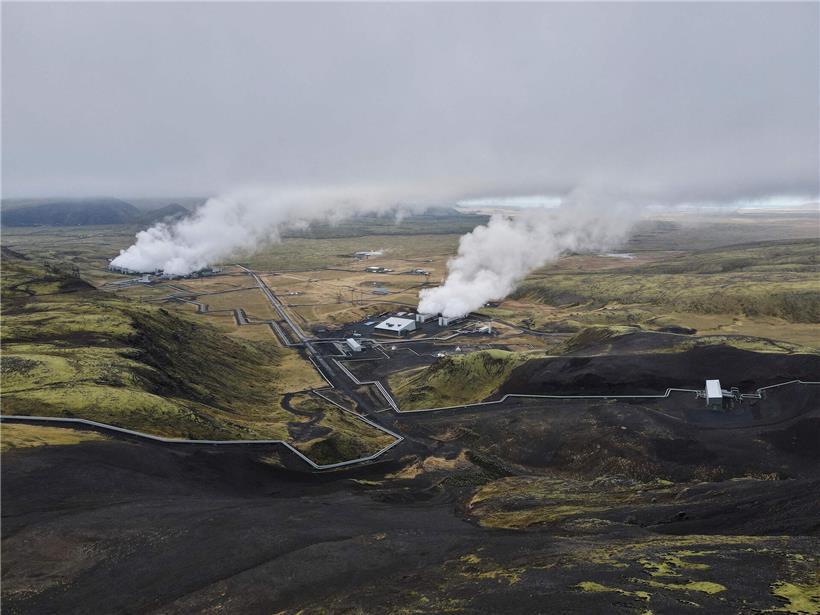 Islandische Vulkanlandschaft mit brodelnder Lava und rauchenden Fumarolen unter dunklem Himmel