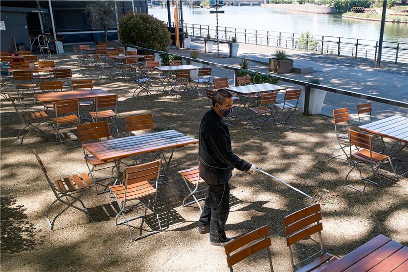 In Rheinland-Pfalz dürfen Biergärten wieder öffnen. Ein Mann überprüft im Biergarten am Deutschen Eck in Koblenz mit einem Zollstock den Abstand der Tische.
