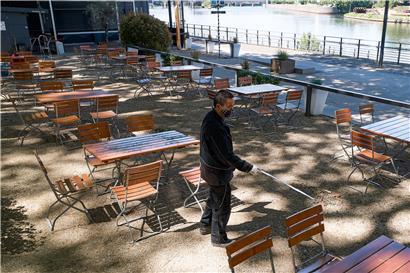 In Rheinland-Pfalz dürfen Biergärten wieder öffnen. Ein Mann überprüft im Biergarten am Deutschen Eck in Koblenz mit einem Zollstock den Abstand der Tische.
