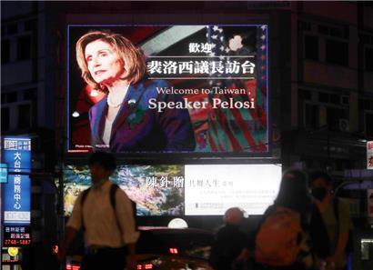 In Taipeh gehen Menschen an einem Plakat vorbei, das die Sprecherin des US-Repräsentantenhauses Pelosi in Taiwan willkommen heißt
