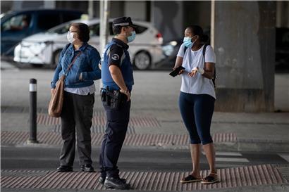 In Teilen Spaniens braucht es wieder einen Grund, um vor die Tür zu dürfen: Ein Polizist spricht mit einer Frau an einem Kontrollpunkt in Vallecas, einem ärmeren Madrider Viertel, das abgesperrt ist
