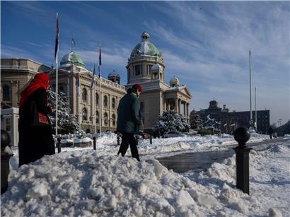 Schneeräumung auf Gehwegen vor dem serbischen Parlament in Belgrad, während die Provinz verschneit bleibt