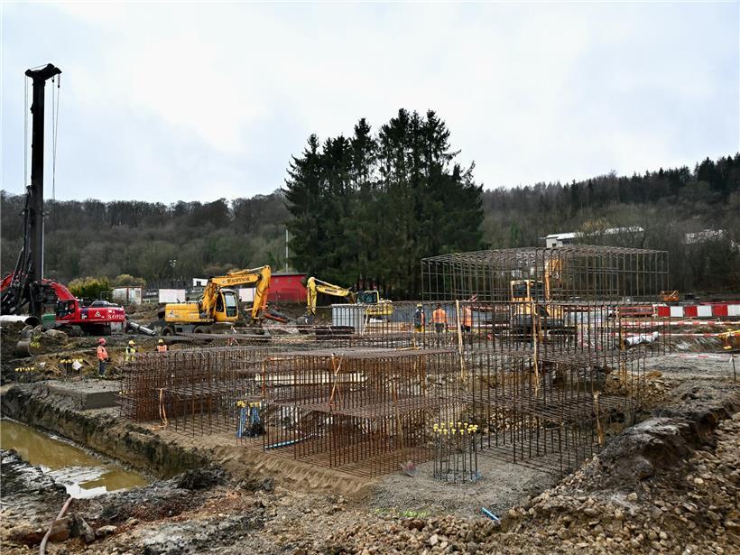 Baustelle für modernes Parkhaus und Energiezentrum neben Hotelbau, Fortschritt bei Rohbauarbeiten sichtbar