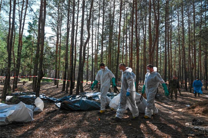 In einem Wald nahe der ukrainischen Stadt Isjum geht die penible Arbeit der Exhumierung von Ukrainerinnen und Ukrainern weiter, die offensichtlich von russischen Truppen ermordet wurden
