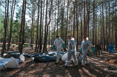 In einem Wald nahe der ukrainischen Stadt Isjum geht die penible Arbeit der Exhumierung von Ukrainerinnen und Ukrainern weiter, die offensichtlich von russischen Truppen ermordet wurden
