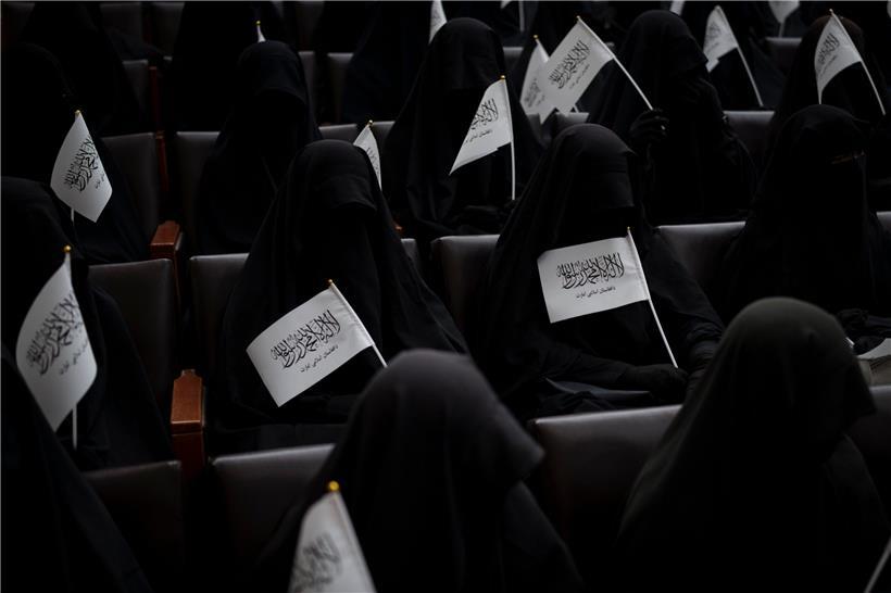 In schwarze Burkas gehüllte Frauen sitzen in einem Hörsaal der Universität in Kabul und halten dabei Fahnen der Taliban in den Händen. Bei einer Demonstration zogen dutzende Frauen über das Gelände der Universität, wo sie ihre Unterstützung für die Regierung der militant-islamistischen Taliban vermittelten.

