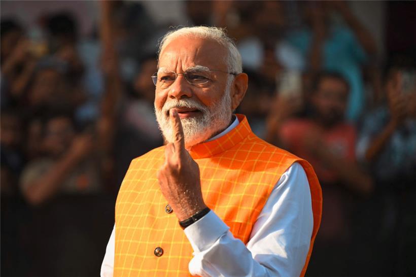 Indiens Premierminister Narendra Modi zeigt seinen mit Tinte markierten Finger, nachdem er in einer Wahlkabine seine Stimme abgegeben hat
