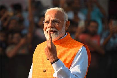 Indiens Premierminister Narendra Modi zeigt seinen mit Tinte markierten Finger, nachdem er in einer Wahlkabine seine Stimme abgegeben hat
