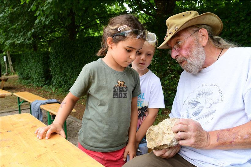 Interesse wecken: Geduldig erklärt Paläontologe Guy Kronz, welche Fossilien sich auf dem Stein befinden. Lyel und Jang staunen – besonders darüber, dass diese Versteinerungen um die 130 Millionen Jahre alt sind.
