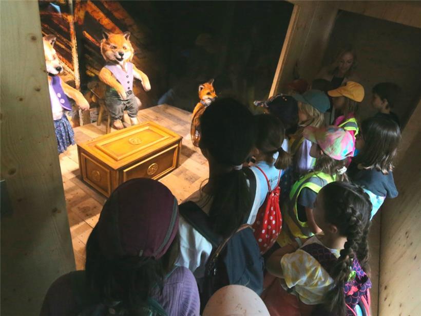 Interessiert lauschen die Kinder den Erläuterungen der lebensgroßen Fuchsfiguren 
