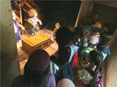 Interessiert lauschen die Kinder den Erläuterungen der lebensgroßen Fuchsfiguren 
