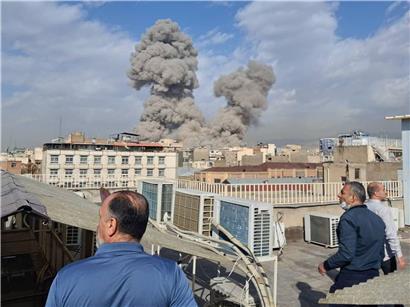 Menschen in Teheran beobachten dichten Rauch nach Explosion in der iranischen Hauptstadt, Sicherheitslage sichtbar