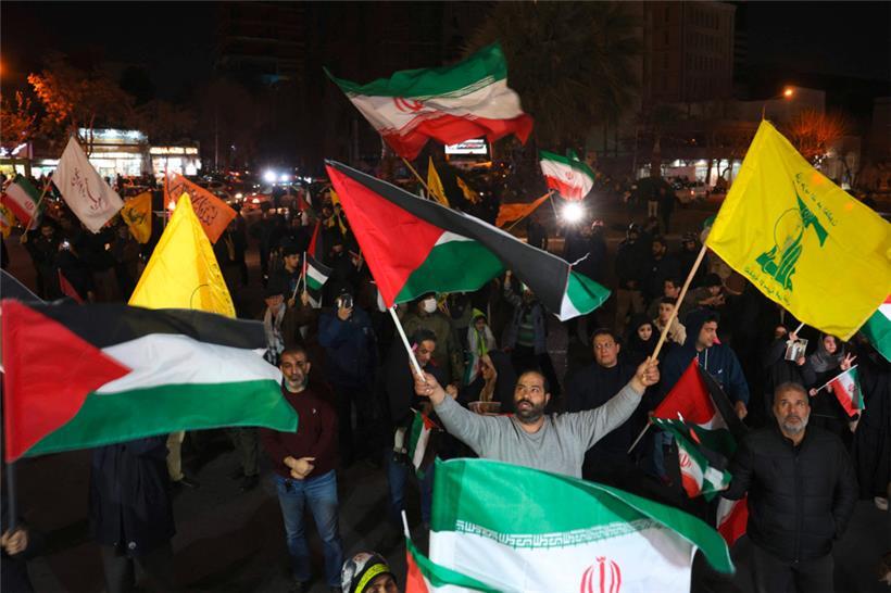 Iraner schwenken palästinensische, Hisbollah- und Nationalflaggen, während sie die Nachricht von der Waffenruhe und der Geiselfreilassung zwischen der Hamas und Israel in Teheran am 16. Januar 2025 feiern
