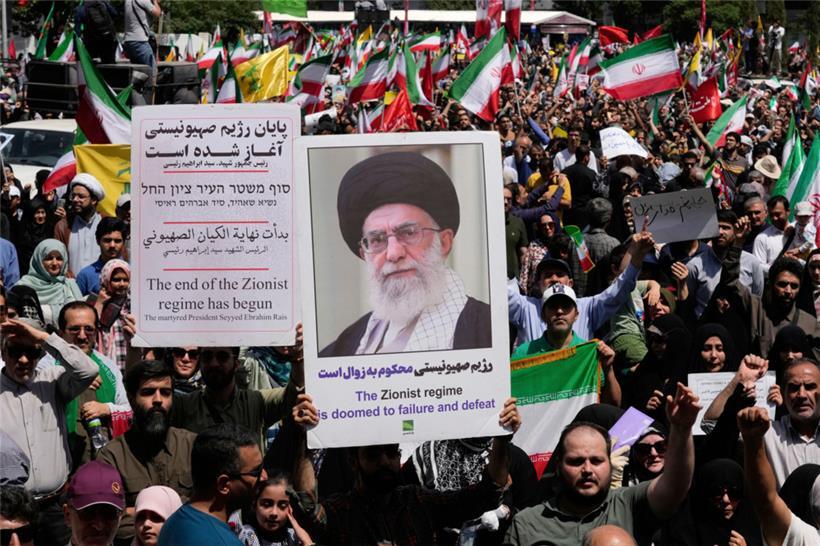 Iranische Demonstranten tragen das Porträt des Obersten Führers Ayatollah Ali Khamenei und anti-israelische Schilder während einer Demonstration
