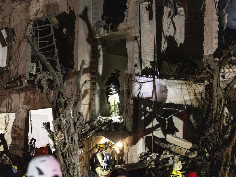 Israelische Sicherheitskräfte untersuchen Einschlagsstelle eines iranischen Raketenangriffs in Tel Aviv bei Nacht