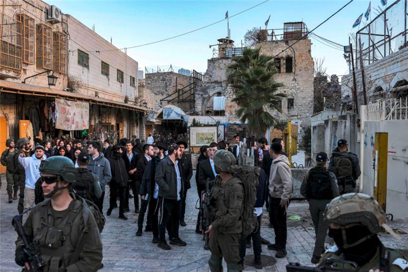 Israelische Soldaten und Sicherheitskräfte begleiten israelische Siedler durch die palästinensische Stadt Hebron im Westjordanland
