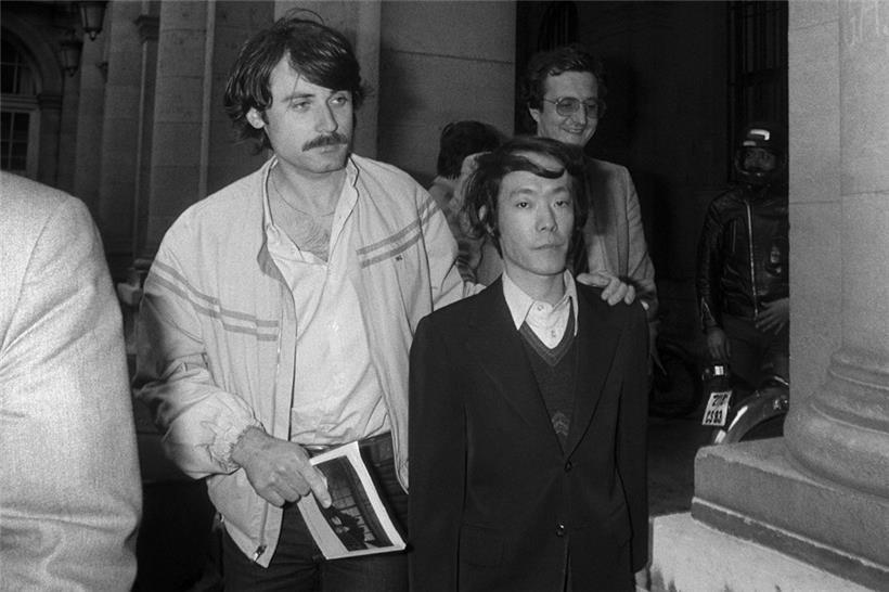 Issei Sagawa (r.) wird nach seinem Verhör im Pariser Polizeipräfektur-Hauptquartier von französischen Polizisten (in Zivil) eskortiert (17. Juni 1981)
