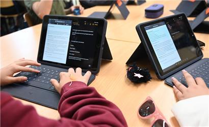 Ist digital besser? Zwei Mädchen arbeiten mit einem KI-Chatbot.
