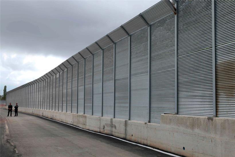 Italienische Polizeibeamte stehen vor dem Zaun eines kürzlich errichteten, von Italien geführten Migrantenlagers am Hafen von Shengjin, etwa 60 km nordwestlich von Tirana
