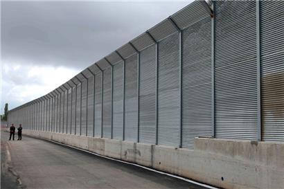 Italienische Polizeibeamte stehen vor dem Zaun eines kürzlich errichteten, von Italien geführten Migrantenlagers am Hafen von Shengjin, etwa 60 km nordwestlich von Tirana
