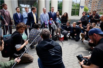 Iwan Pawlow (M.), Anwalt des inhaftierten Kremlgegners Nawalny, spricht während einer Verhandlungspause an einem Moskauer Gericht mit Journalisten
