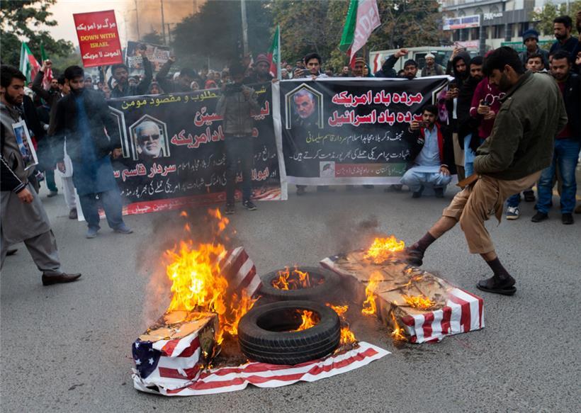 Januar 2020, Pakistan, Islamabad: Schiitische Muslime aus Pakistan verbrennen während einer Demonstration gegen einen US-Luftangriff im Irak, bei dem der iranische General Soleimani getötet wurde, Flaggen der Vereinigten Staaten
