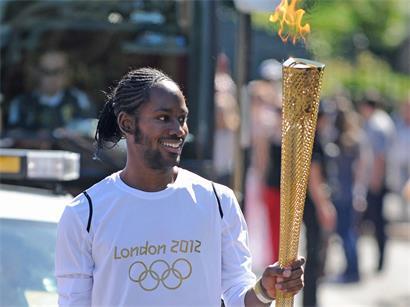 Jason Arday, trägt 2012 die olympische Fackel auf der Etappe des Fackellaufs zwischen Sutton (Londoner Stadtbezirk) und Merton (Londoner Stadtbezirk)