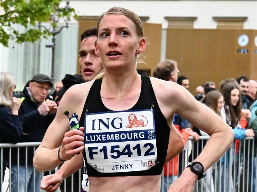 Jenny Gloden läuft als Siegerin beim Halbmarathon über die Ziellinie in Sportkleidung