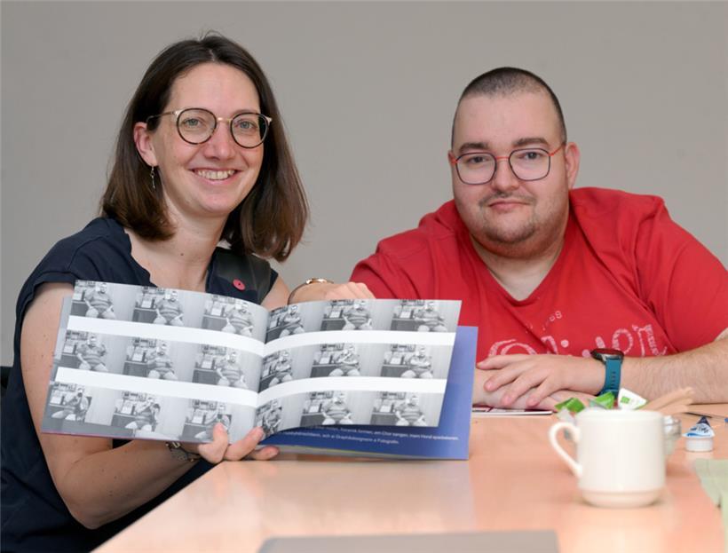 Jessica Theis und Eric Heimermann posieren mit dem Begleitkatalog zu „Wee bass du?“
