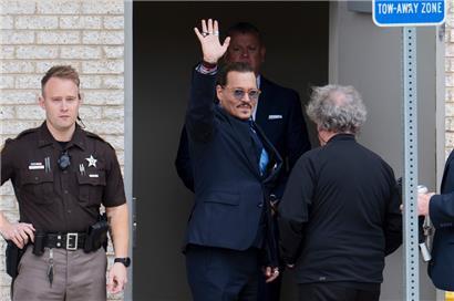 Johnny Depp (Mitte) winkt seinen Anhängern vor dem Fairfax County Courthouse in Fairfax zu
