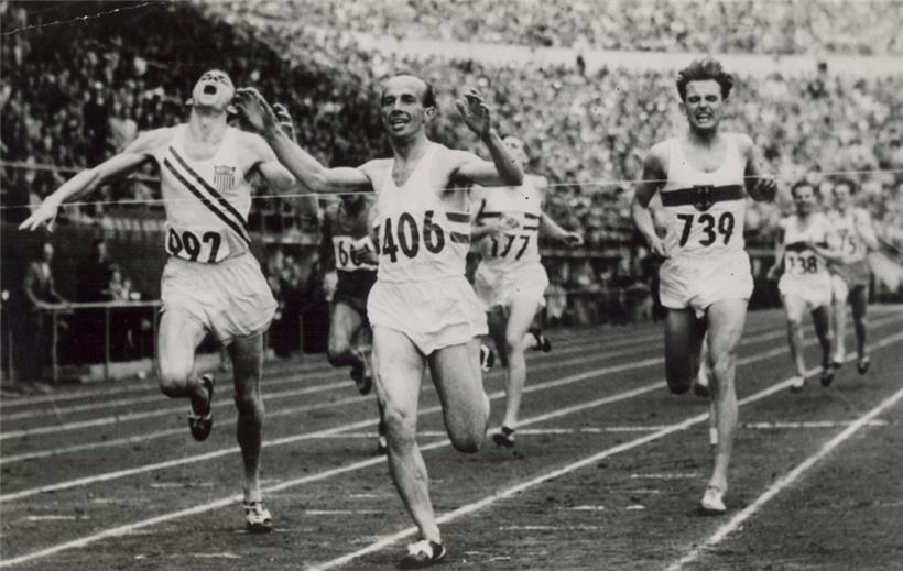 Josy Barthel läuft als Olympiasieger ins Ziel, links der Amerikaner Robert McMillen, rechts der Deutsche Werner Lueg
