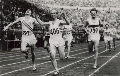 Josy Barthel läuft als Olympiasieger ins Ziel, links der Amerikaner Robert McMillen, rechts der Deutsche Werner Lueg
