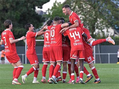 Jubelnde Straßenfans feiern den Erfolg ihres Teams im Hinspiel bei strahlendem Sonnenschein