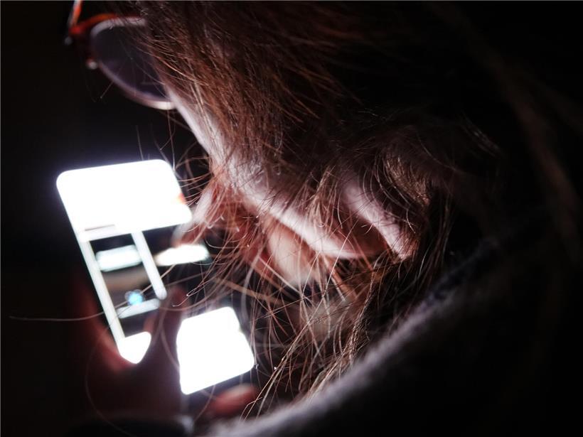Jugendliche nutzen intensiv soziale Medien auf dem Smartphone, Symbol für digitale Abhängigkeit und Medienkonsum