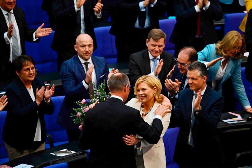 Julia Klöckner (r.) erhält Blumen, während sie von Friedrich Merz beglückwünscht wird, nachdem sie zur neuen Bundestagspräsidentin gewählt wurde
