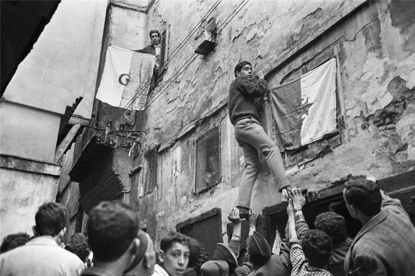 Junge Algerier hängen am 6. Juli 1962, einen Tag nach der Unabhängigkeitserklärung 1962, eine Flagge im Altstadtviertel Kasbah in Algier auf
