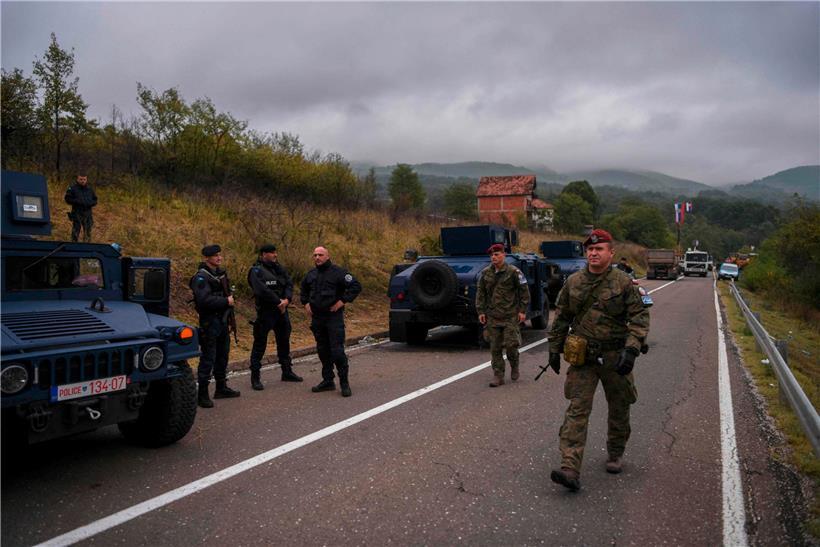 KFOR-Soldaten marschieren am serbisch-kosovarischen Grenzübergang Jarinje an Mitgliedern einer Sondereinheit der Polizei Kosovos vorbei
