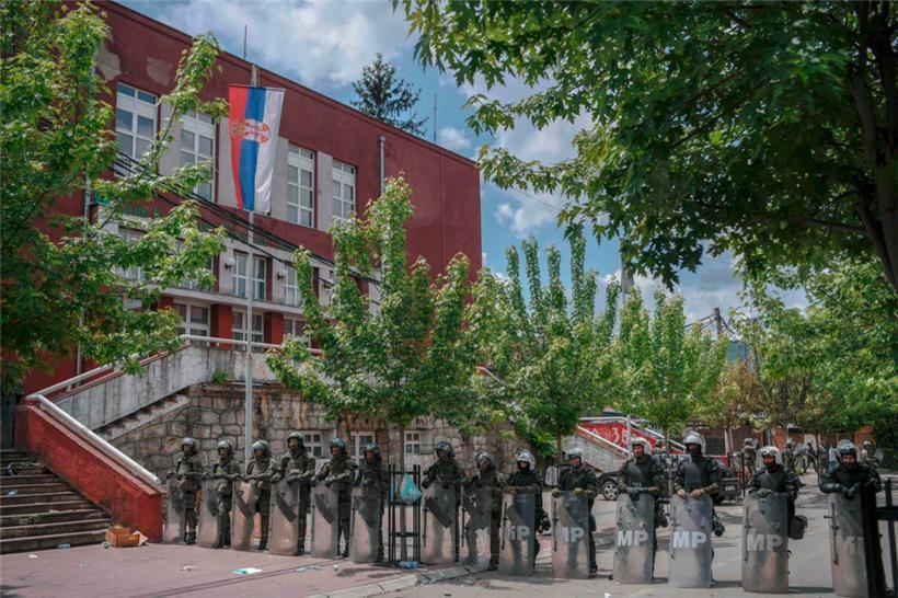 KFOR-Soldaten und Kosovo-Polizisten bewachen ein städtisches Gebäude
