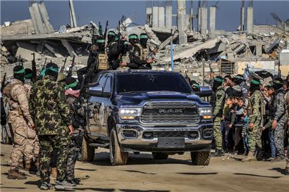 Kämpfer der Brigaden Islamischer Dschihad und Al-Kassam, des militärischen Flügels der Hamas, treffen im südlichen Gazastreifen ein, um drei israelische Geiseln an Vertreter des Roten Kreuzes zu übergeben
