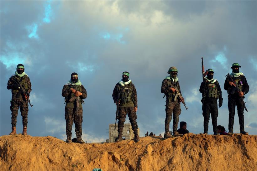 Kämpfer der Terrororganisation Hamas gehen in Stellung, bevor sie die Leichen von vier israelischen Geiseln, darunter eine Mutter und ihre beiden Kinder, die seit langem für tot gehalten wurden, dem Roten Kreuz in Chan Junis im südlichen Gazastreifen übergeben wollen
