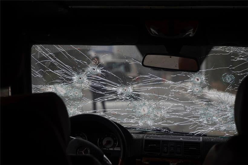 Kasachstan, Almaty: Das Glas der Windschutzscheibe eines Polizeiautos auf einer Straße ist zerbrochen und mit Einschusslöchern versehen

