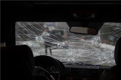 Kasachstan, Almaty: Das Glas der Windschutzscheibe eines Polizeiautos auf einer Straße ist zerbrochen und mit Einschusslöchern versehen
