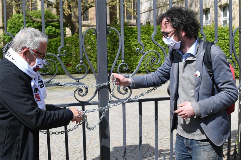 Kein (Informations-)Zugang: Roger Infalt und der Journalist Luc Caregari (rechts) verschließen bei einem Protest für das Informationszugangsgesetz im Mai 2021 symbolisch das Tor des Staatsministeriums
