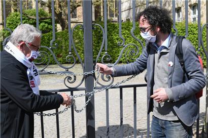 Kein (Informations-)Zugang: Roger Infalt und der Journalist Luc Caregari (rechts) verschließen bei einem Protest für das Informationszugangsgesetz im Mai 2021 symbolisch das Tor des Staatsministeriums
