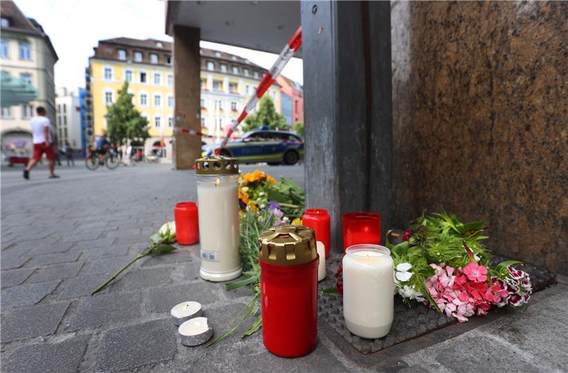 Kerzen und Blumen liegen vor einem geschlossenen und abgesperrten Geschäft in Würzburg. In der Innenstadt hat ein Mann am Vortag wahllos Menschen mit einem Messer attackiert. Drei Menschen starben, mindestens fünf wurden schwer verletzt.

