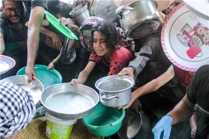 Kinder strecken ihre Gefäße aus, um in der Stadt Beit Lahia im nördlichen Gazastreifen Nahrung zu bekommen
