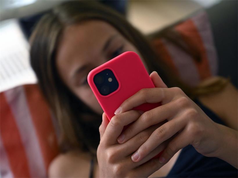Kind hält Mobiltelefon in der Hand, Eltern nutzen Handy zur Beruhigung von Kindern, digitales Entertainment für Kinder