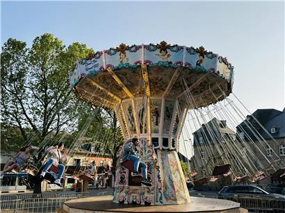 Klassische Fahrgeschäfte auf Jahrmarkt mit nostalgischer Atmosphäre bei sonnigem Wetter