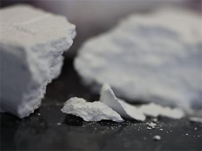 Kokainpulver auf weißem Hintergrund symbolisiert hohe Gewinnmargen im illegalen Drogenhandel