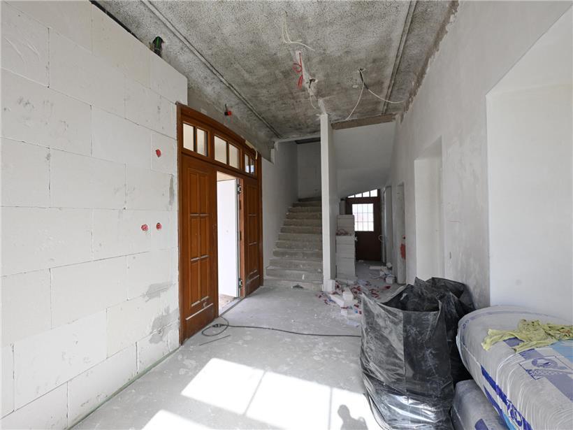 Neues Leben rund um die alte Schule in Peppingen – 22 Wohnungen geplant Baustelle im Sommer mit fast fertiggestelltem Gebäude und klarem Himmel, Sommerprojekt im Bauprozess